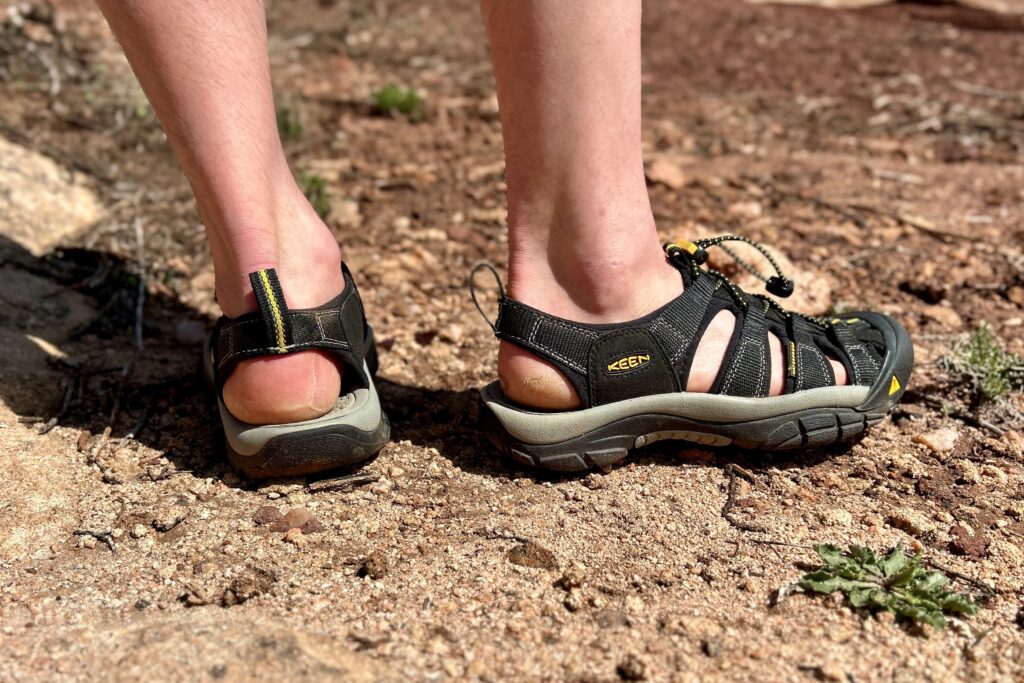 Close up image of a person standing in hiking sandals