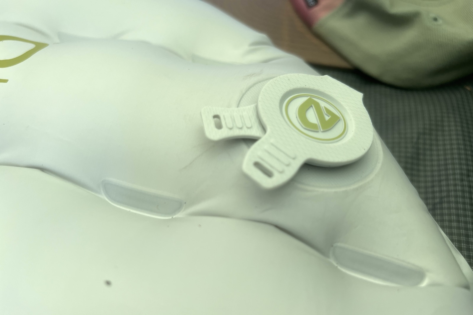 A close up of the air valve on a gray sleeping pad