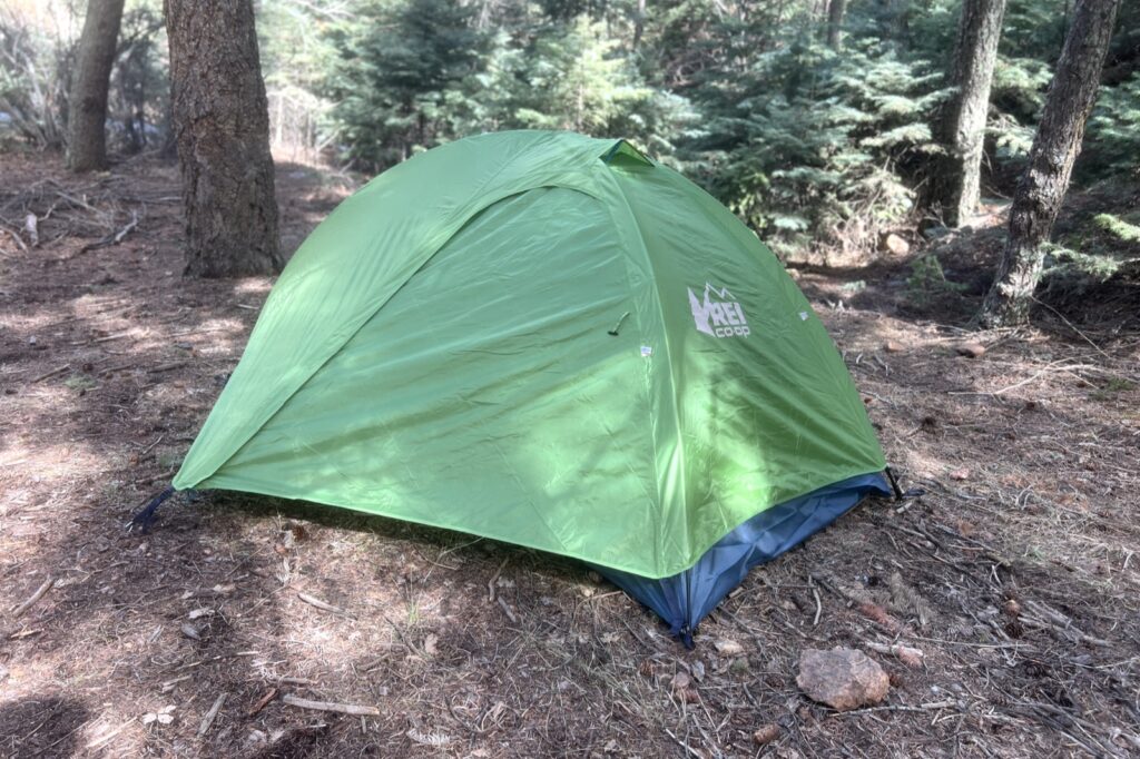 a green tent in a forest