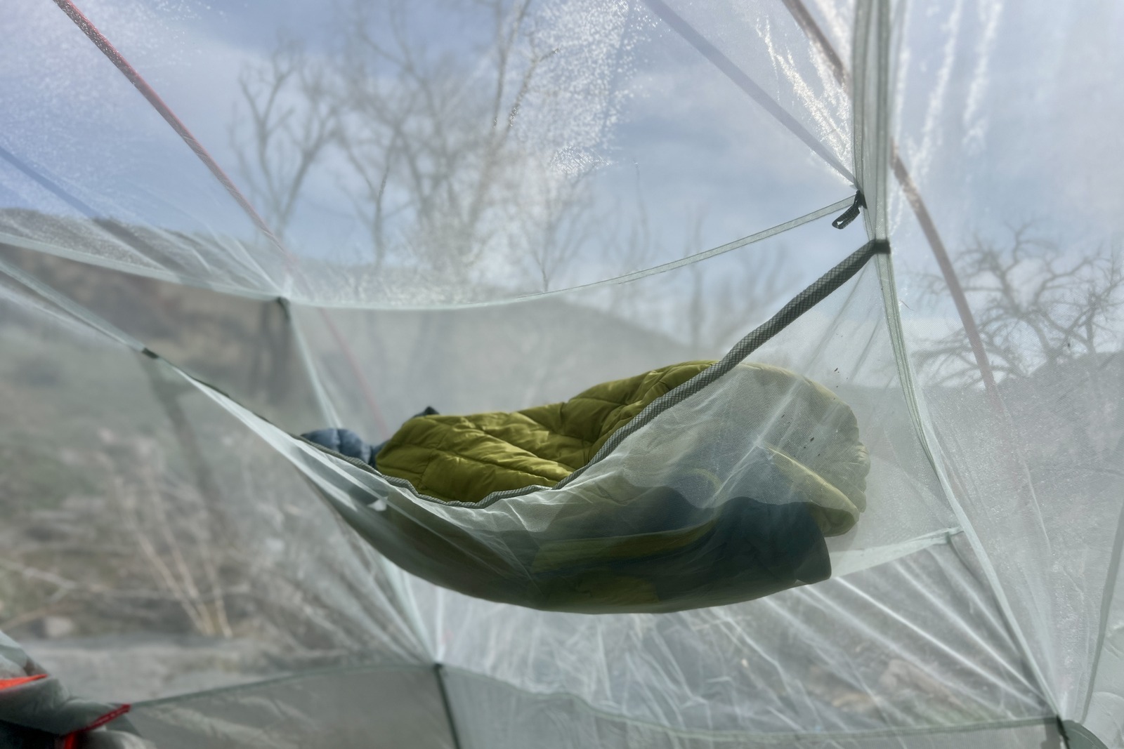 A puffy jacket in the mesh gear loft of a tent