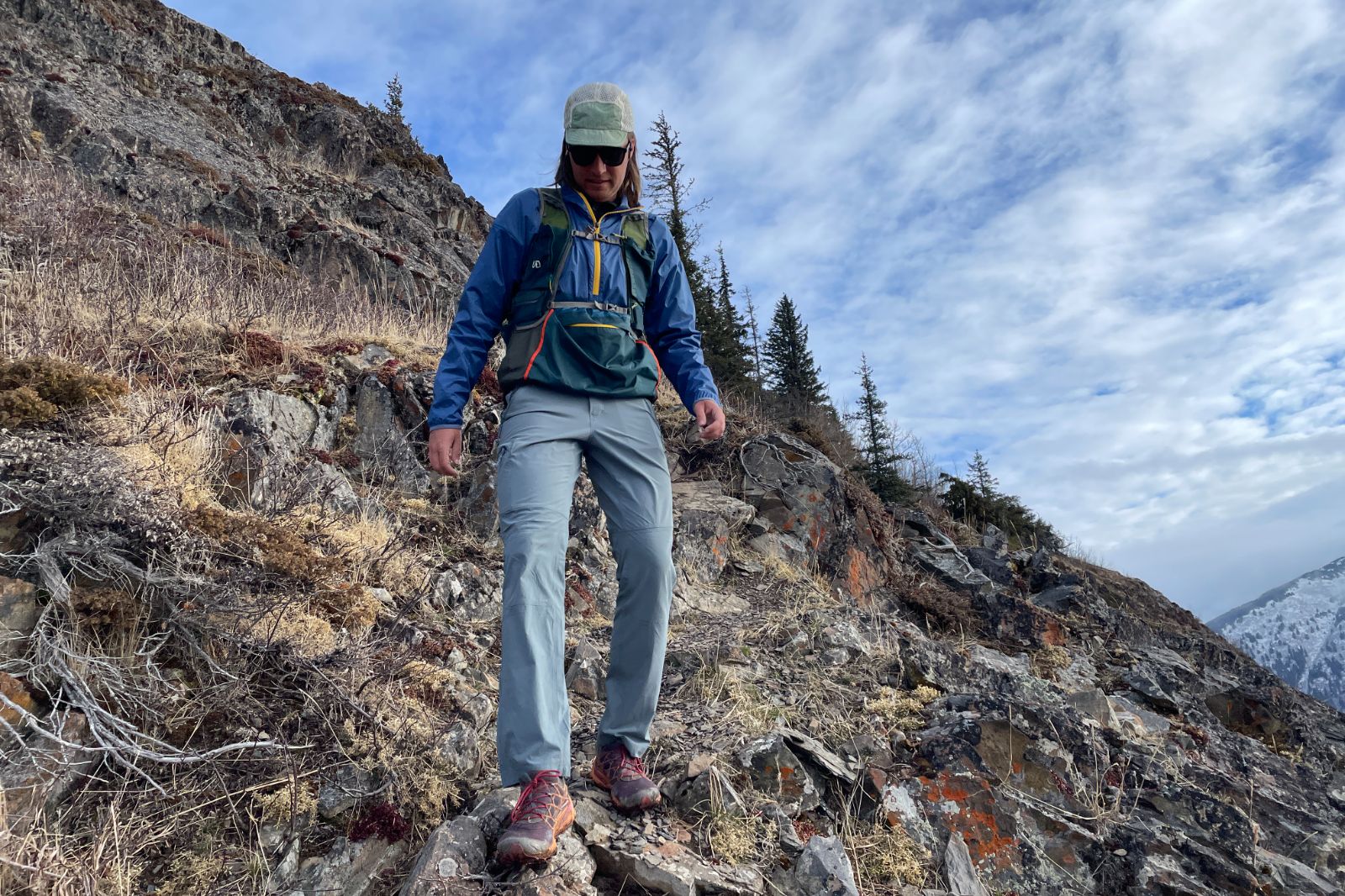 A man hikes down a rocky trail.