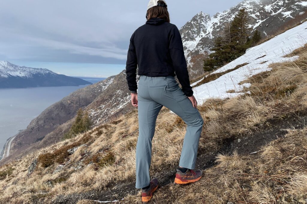 A man faces away from the camera with a mountain view.