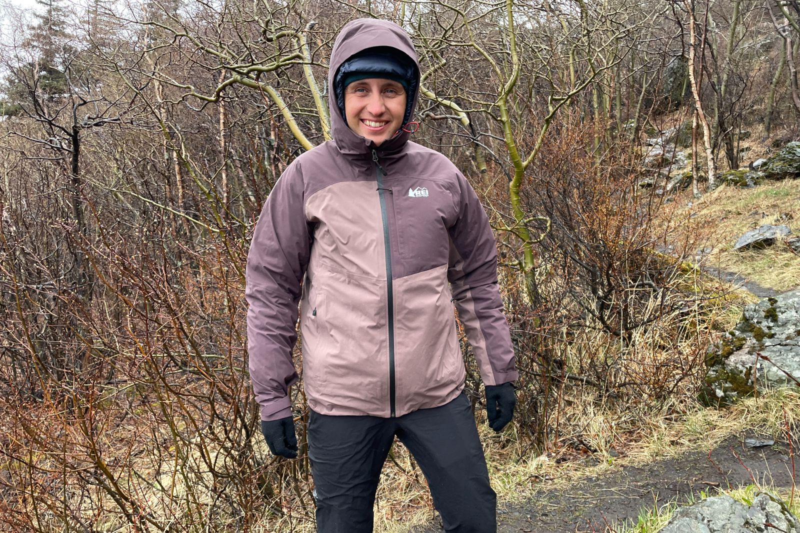 A man hikes in the rain on a trail