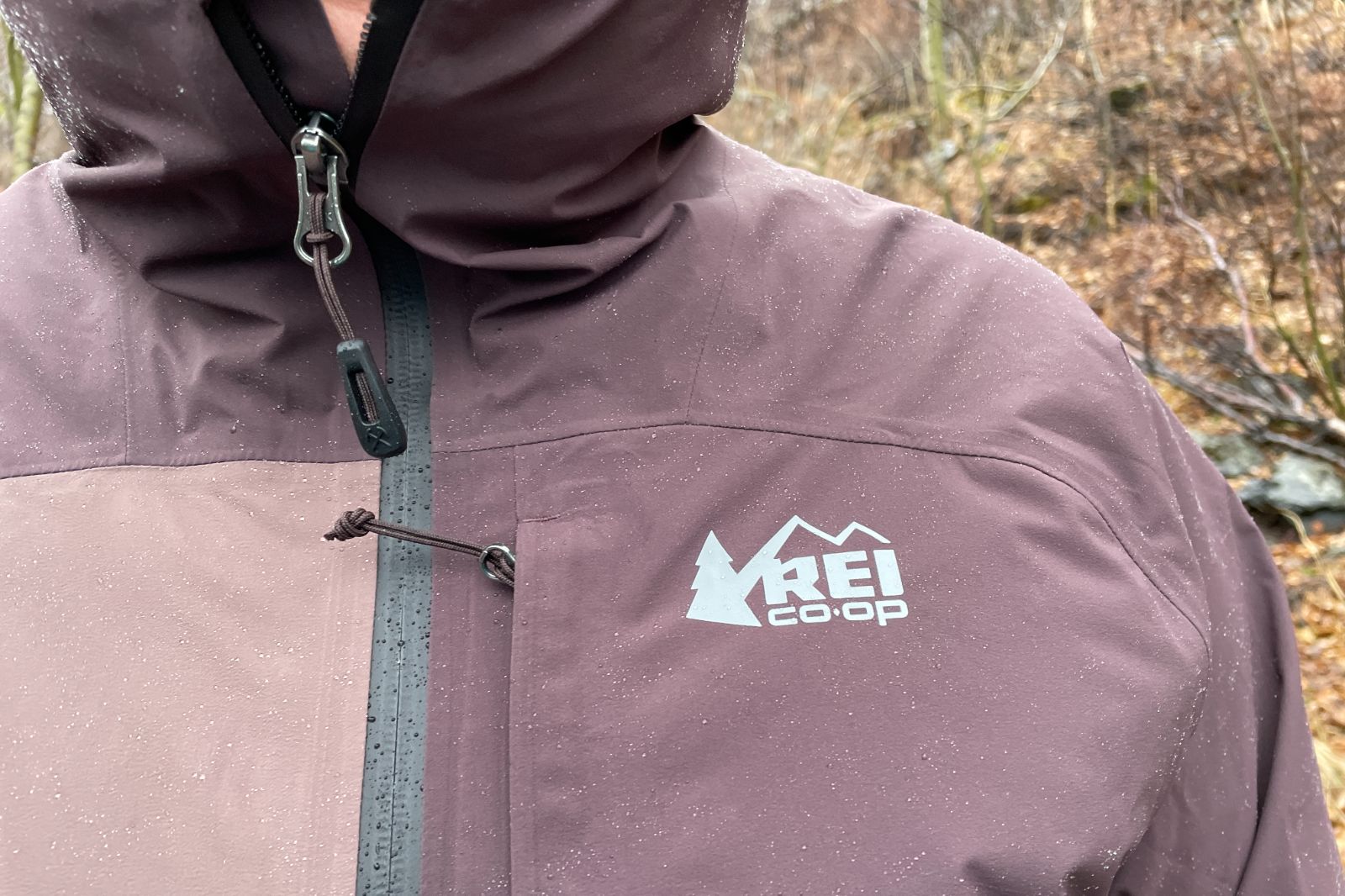 A closeup of the logo of a rain jacket with rain on it.