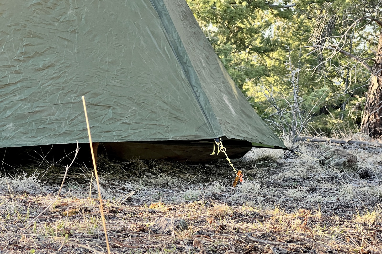 a close up of the bottom of a trekking pole tent, showing the gap between the ground and the vestibule