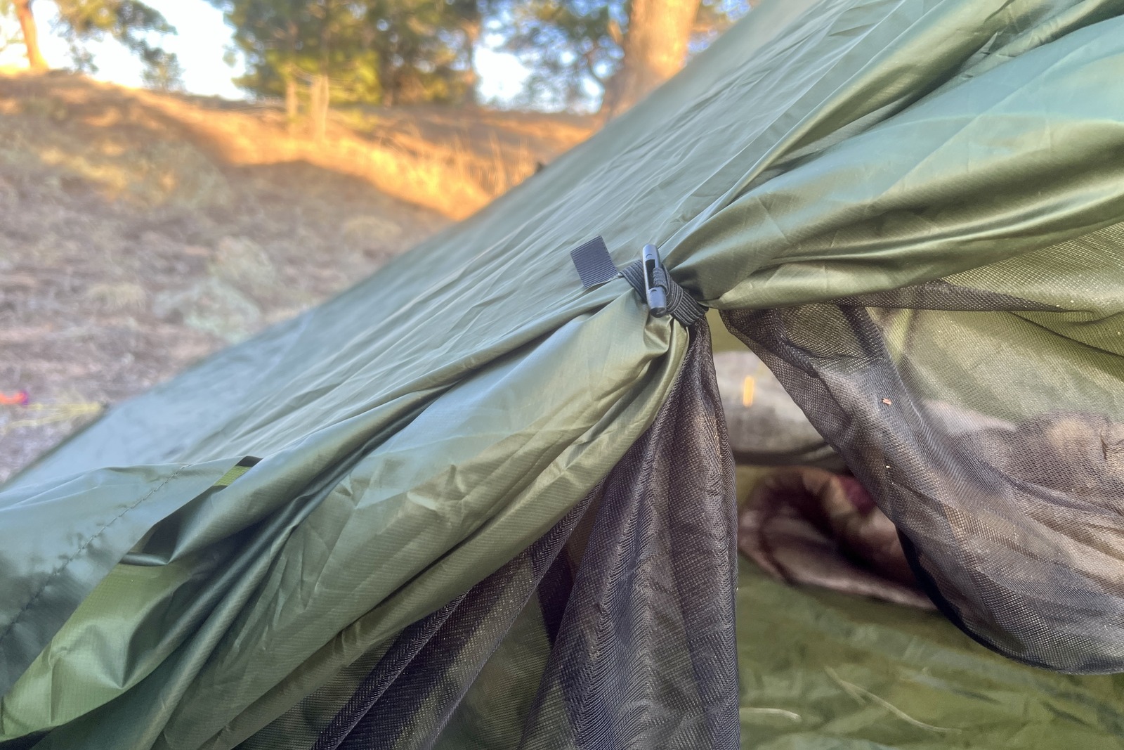 A close up of the door tie back on a green tent