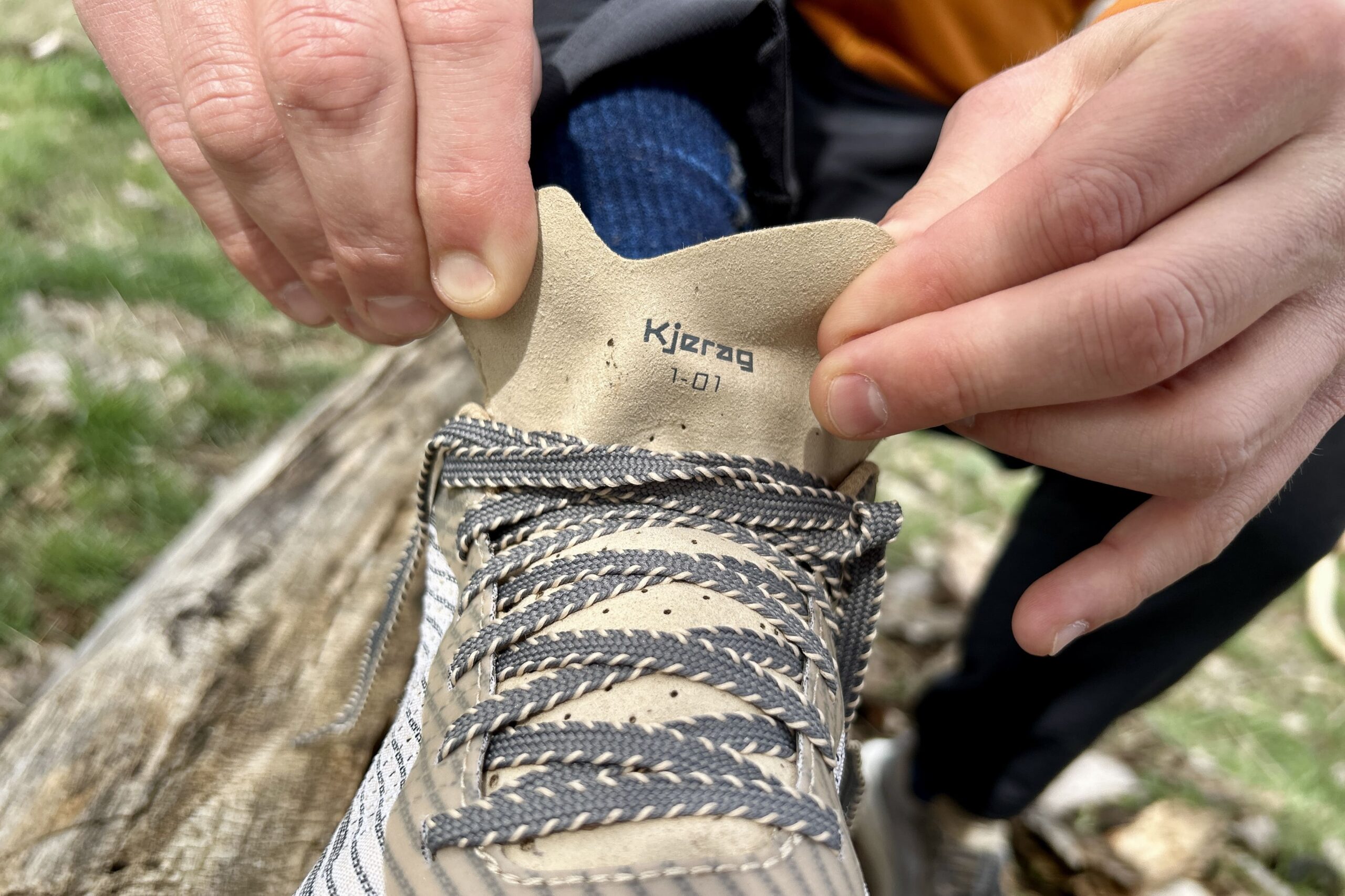 Close up image of the thin tongue on a pair of trail runners with an offset cutout design.