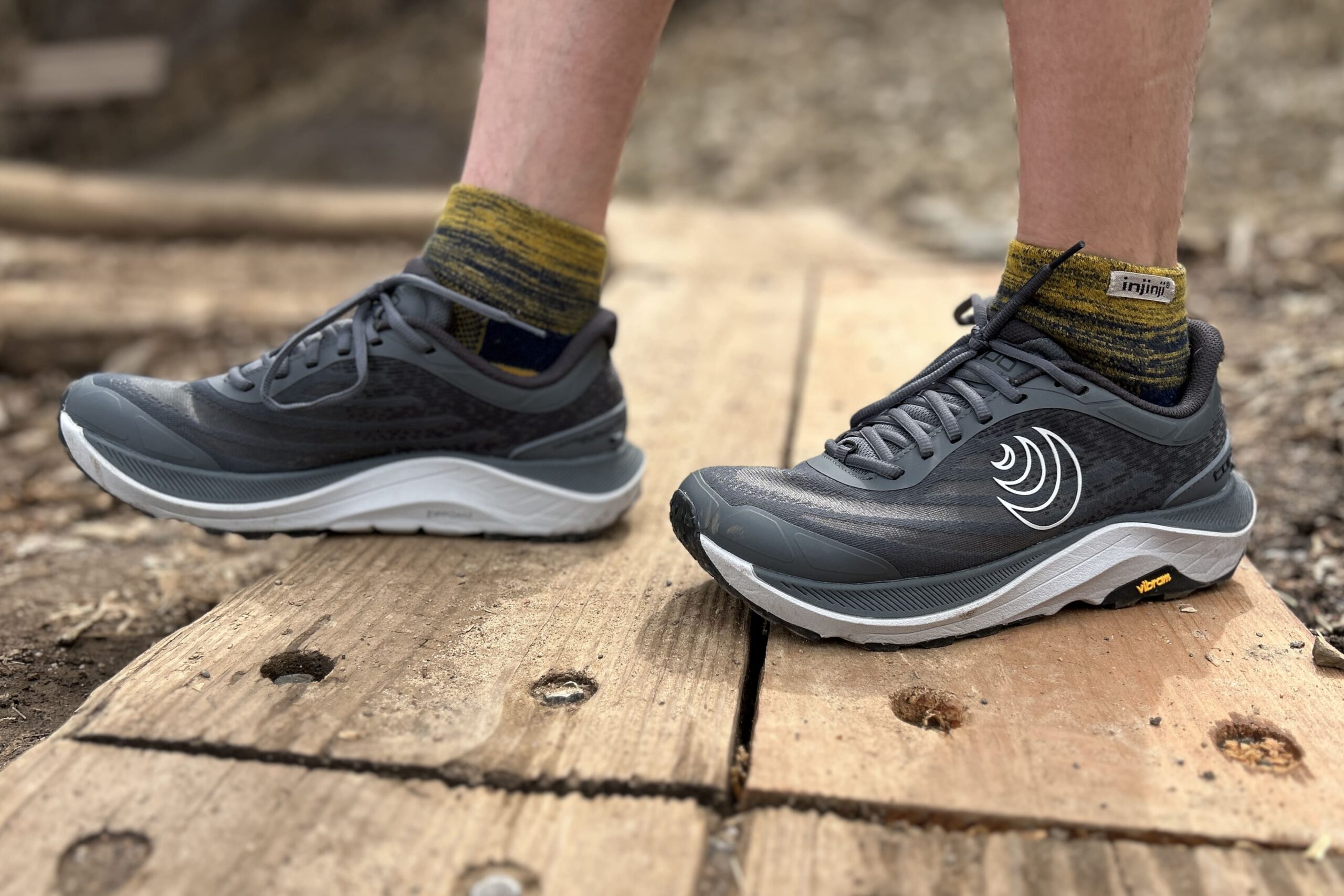 Close up from the knees down of a person wearing trail runners.