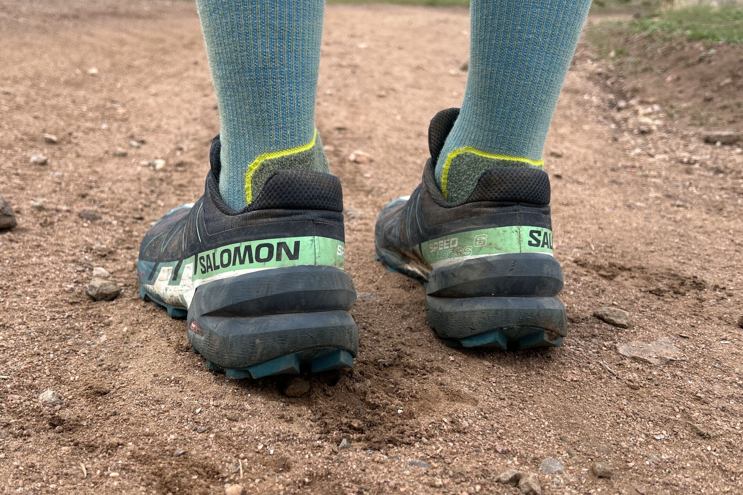 Close up image of a pair of trail runners from behind, showing the structured heel.