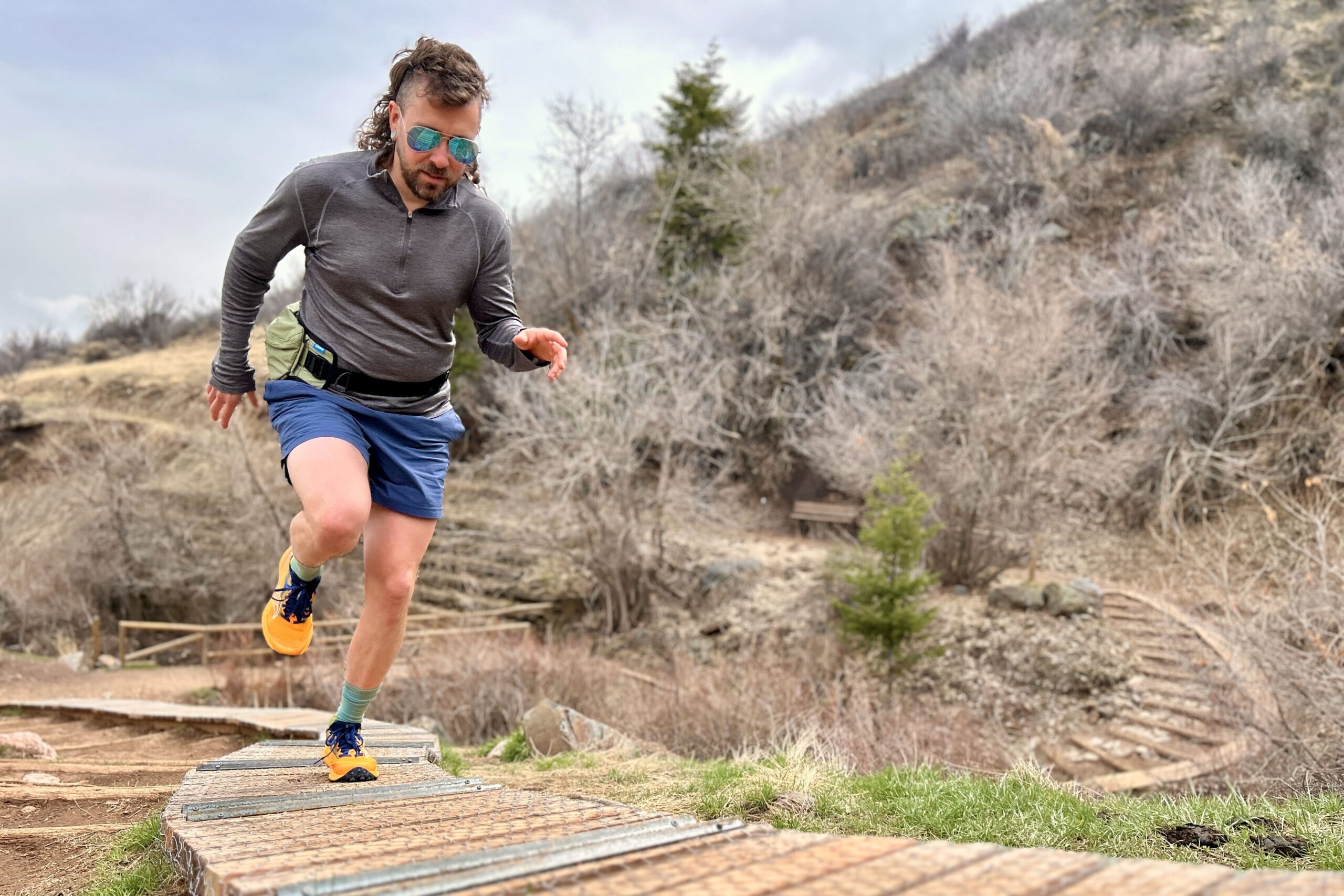 A man runs uphill on a wooden section of trail.