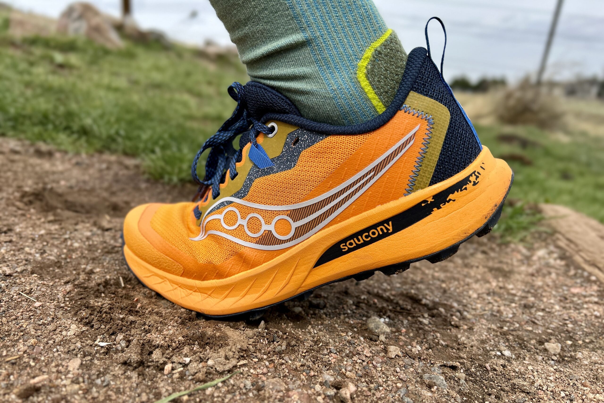 Close up image of a trail runner from the side, flexing on an uphill section.
