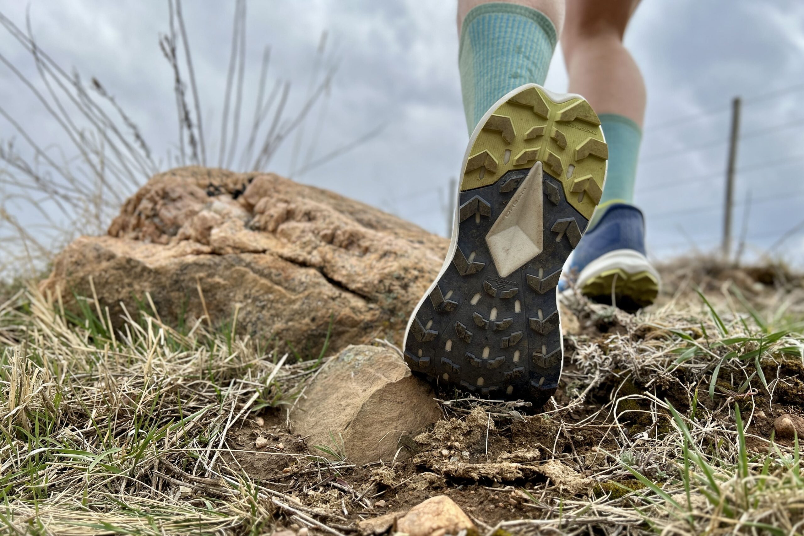 Close up of the bottom of a pair of trail runners showing off the traction pattern.