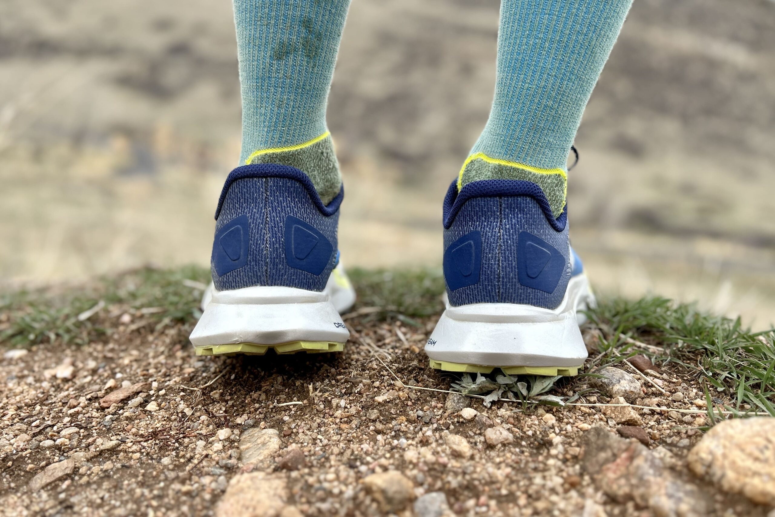 Close up from behind of the heels of a pair of trail runners.