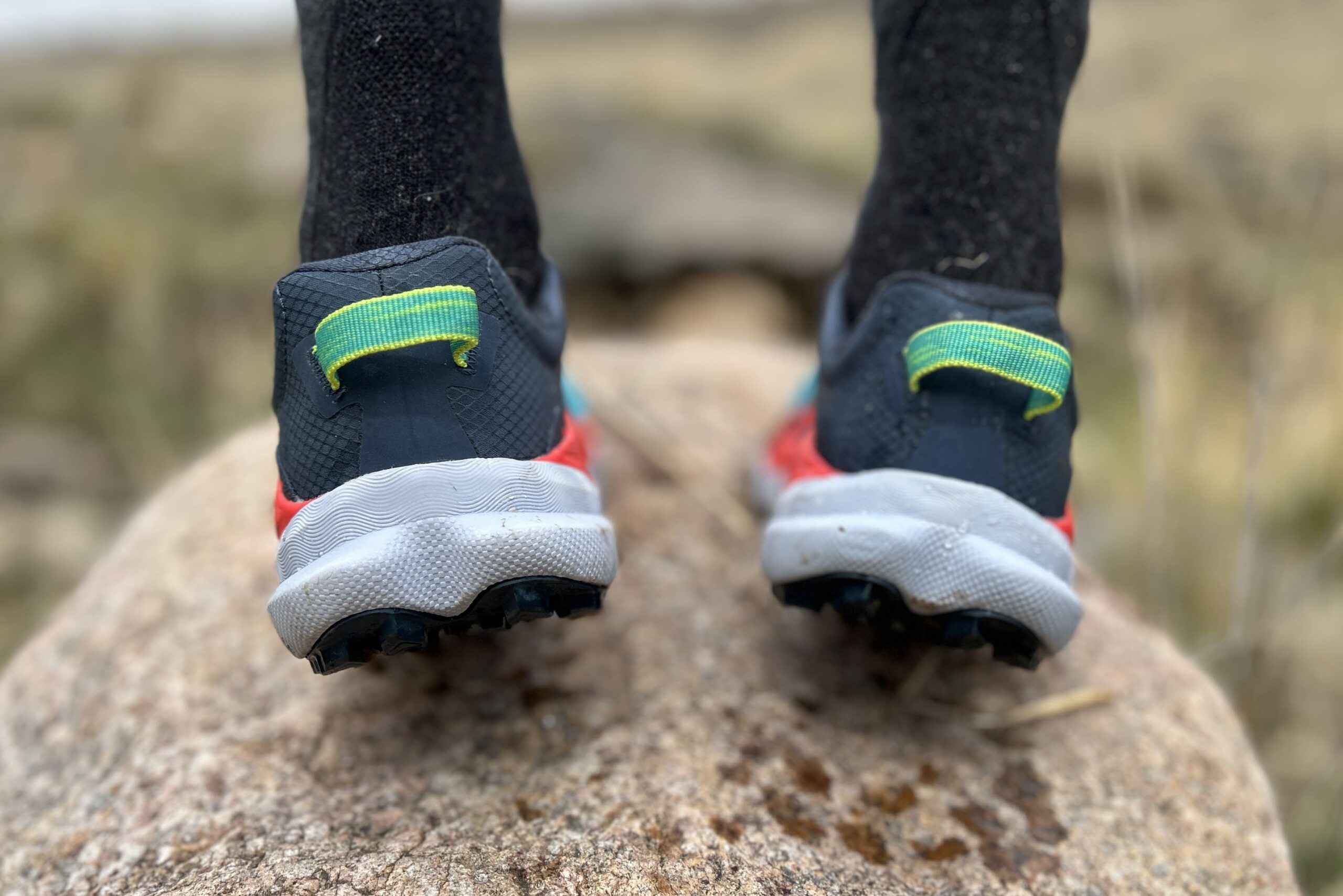 Close up image of the heels and heel loops on a pair of trail running shoes.