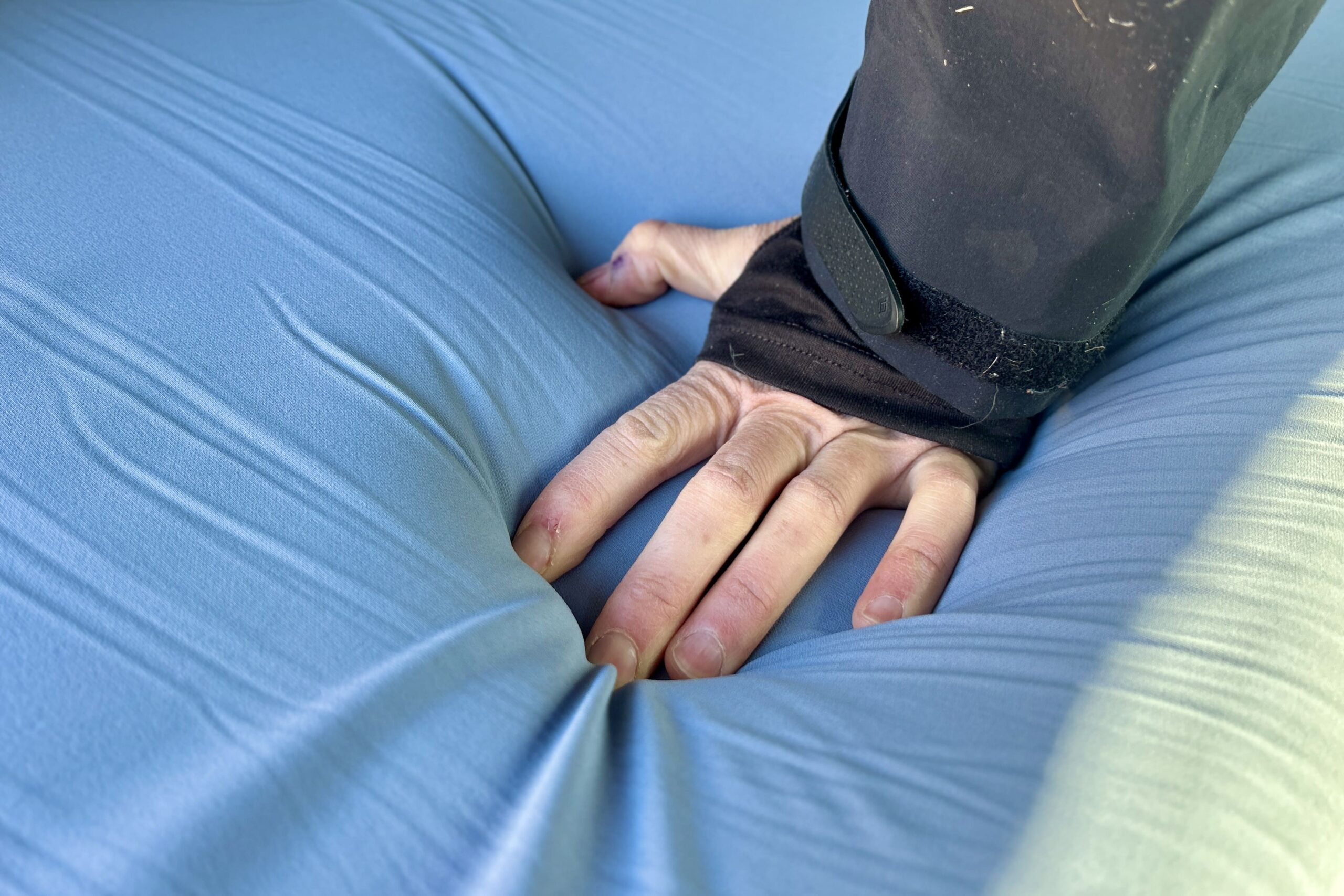 Close up image of a hand pushing into a camping mattress, showing how cushy and soft it is.