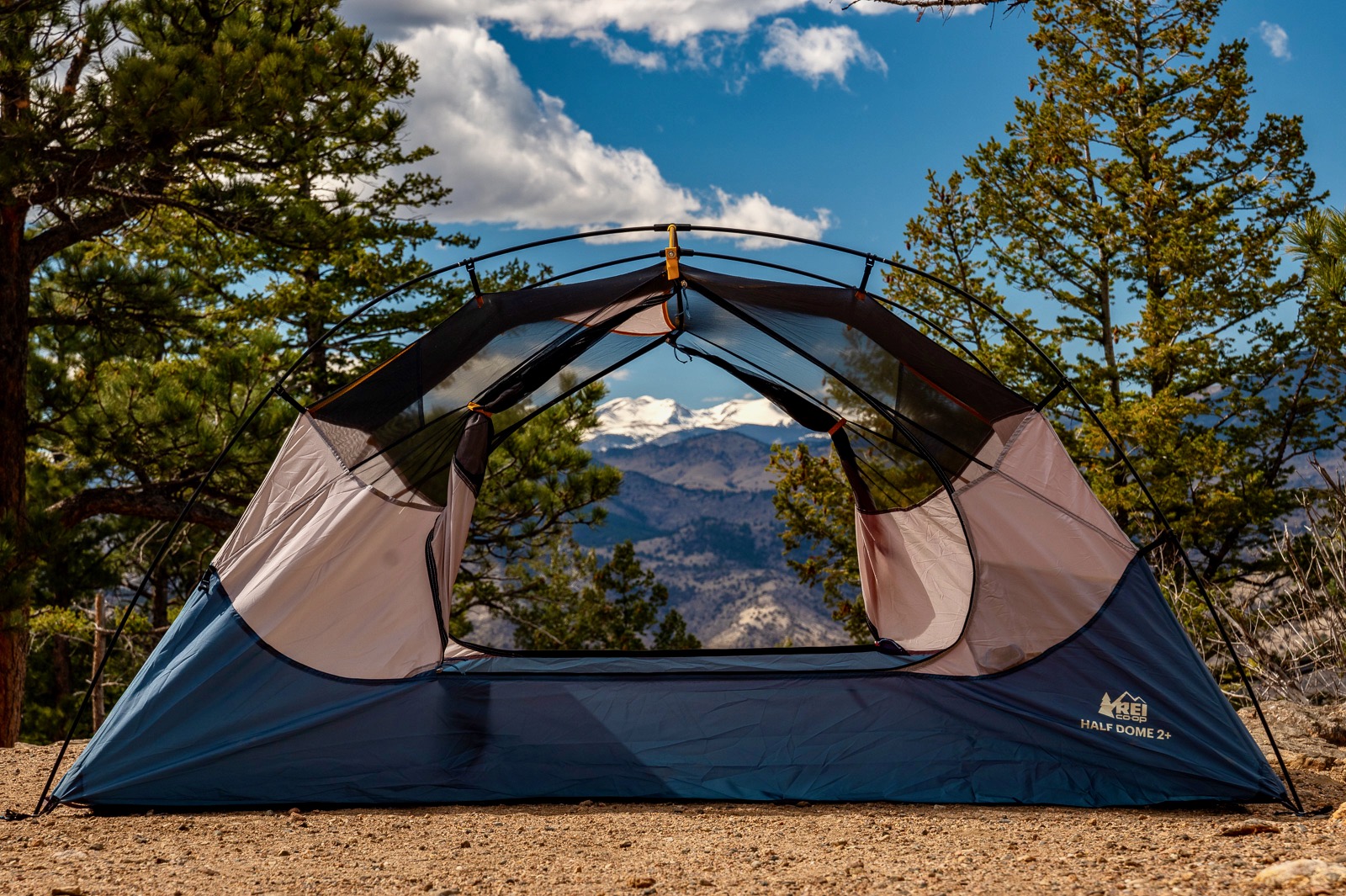 a tent is setup without its rain fly, doors open, with a mountain view