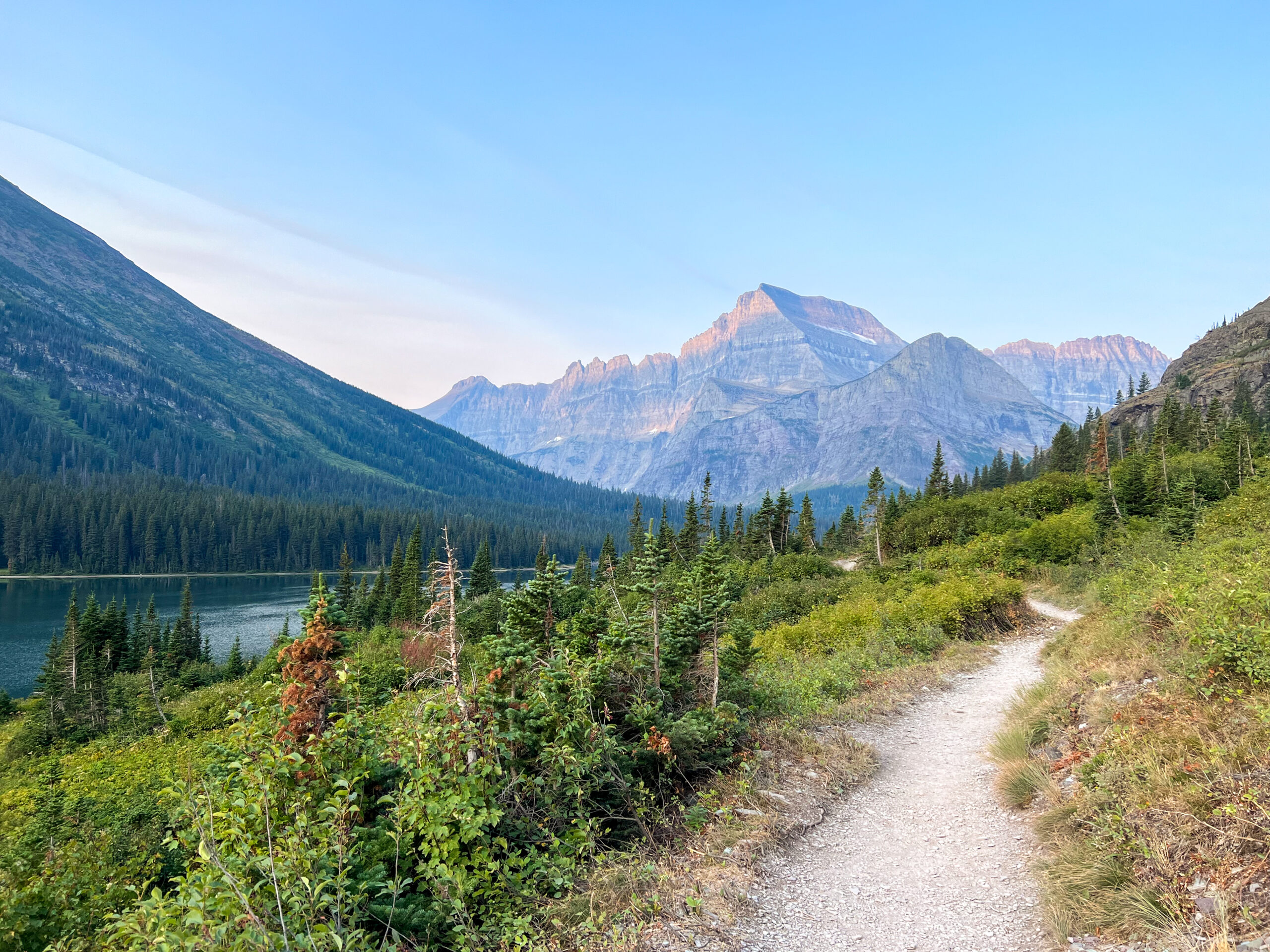 a mountain above a trail during sunrise