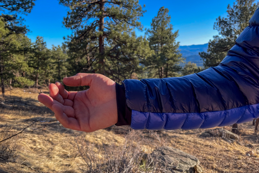 the arm of a man with a blue jacket. The cuff of the jacket is the focus of the photo.