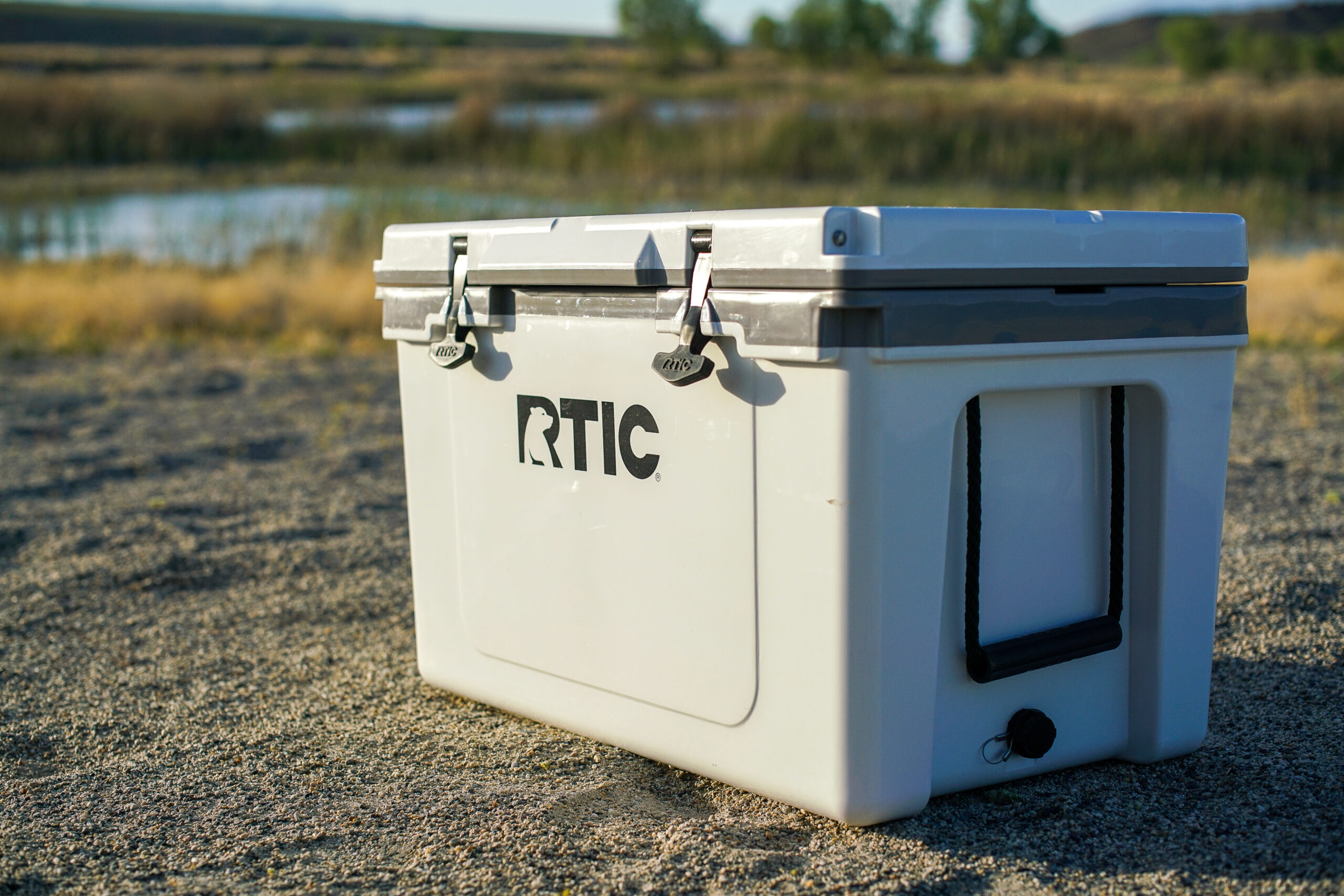 The RTIC Ultralight 52 sits on sandy ground with a body of water in the background.