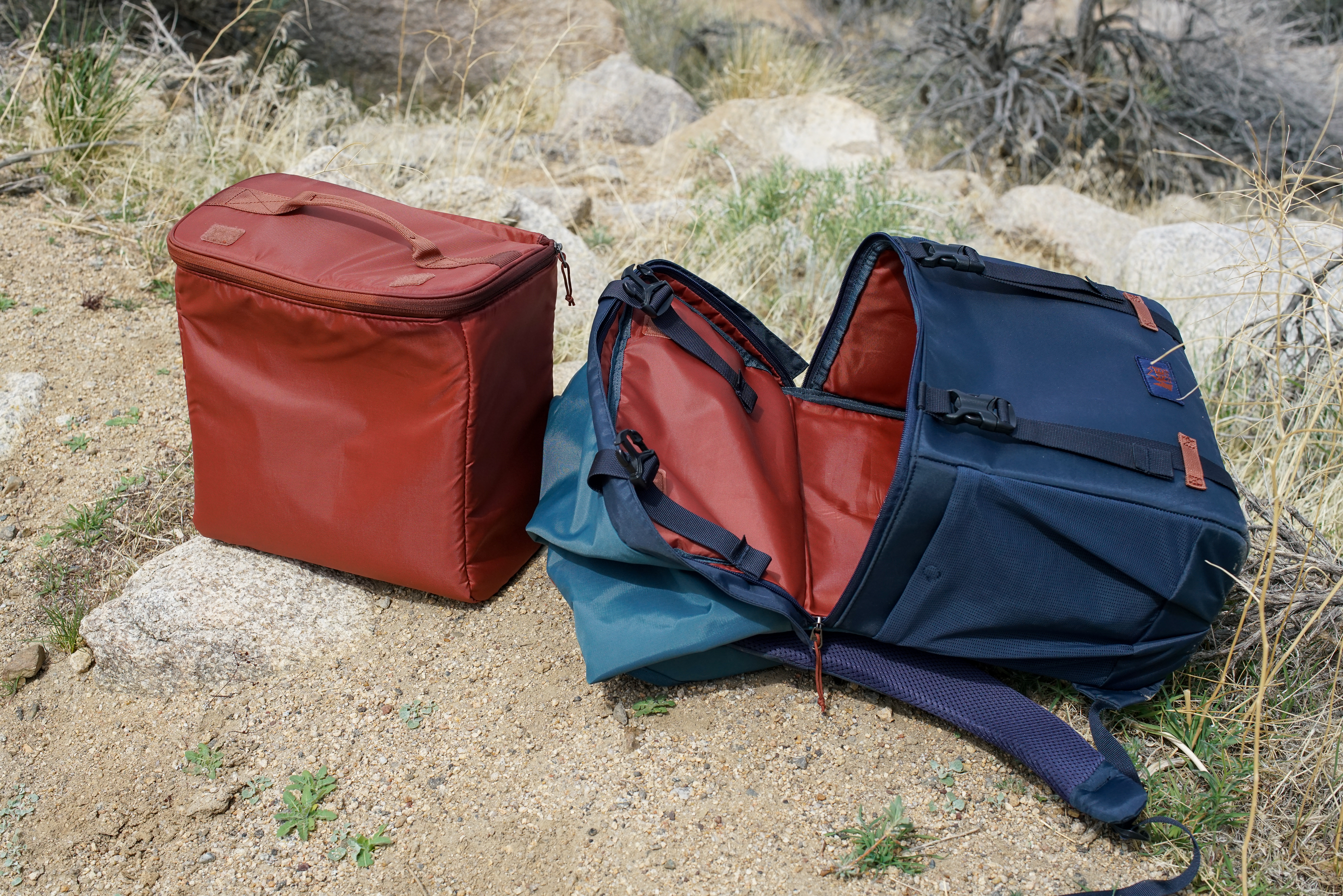 The removable cooler insert of the REI Cool Trail Split Pack sits on the ground next to the rest of the pack.