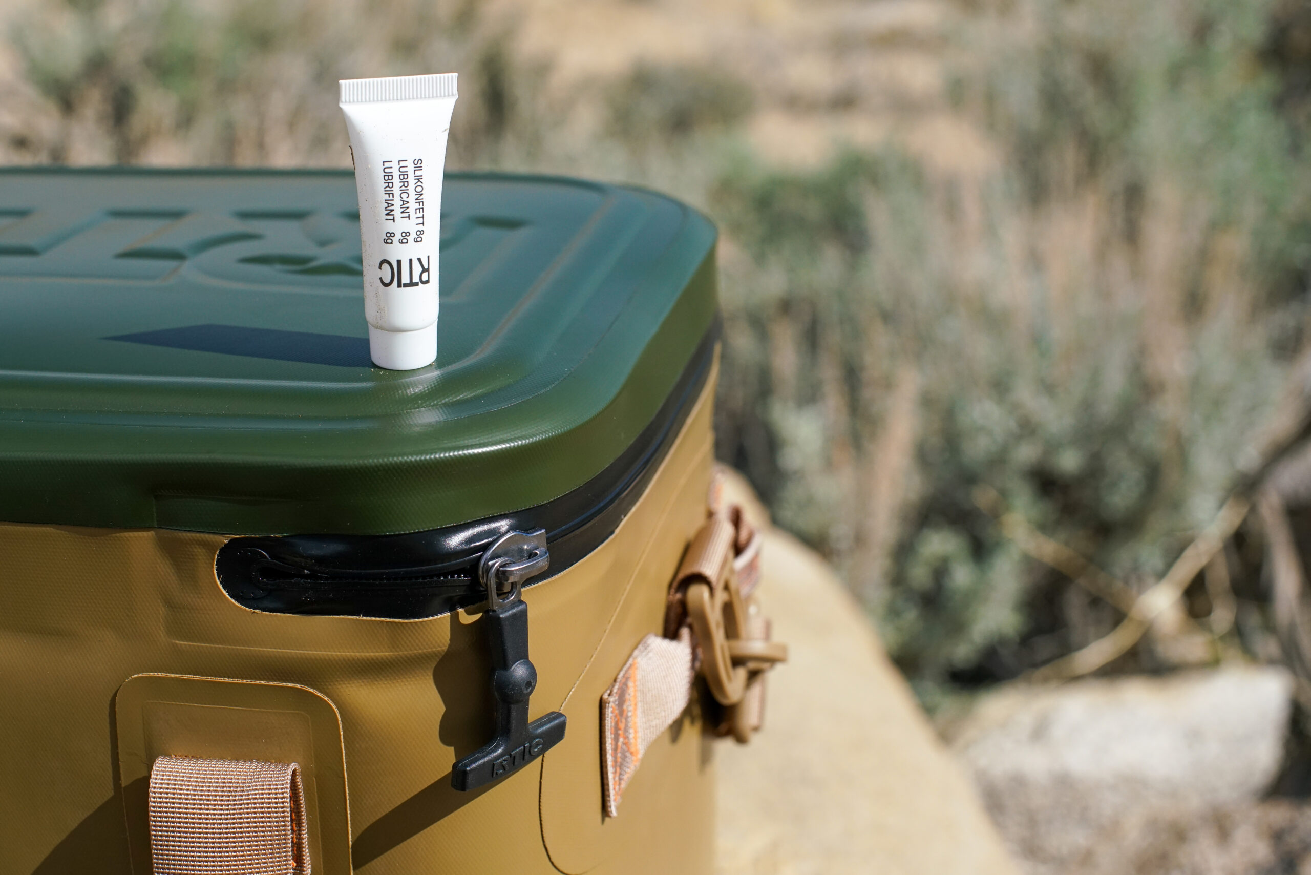A close up of a tube of lubricant sitting on top of the RTIC Soft Pack cooler.