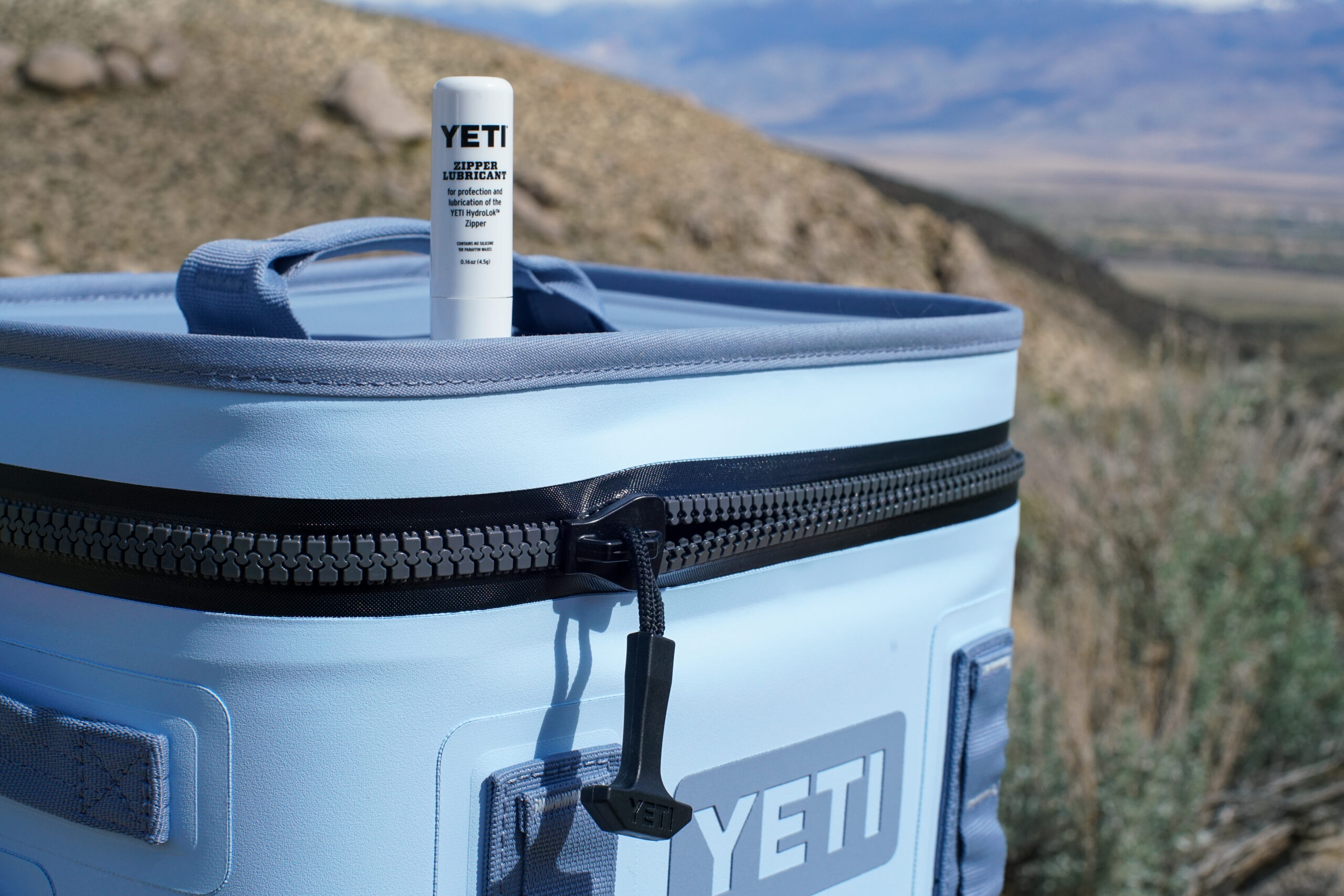 A close up of a tube of zipper lubricant on top of the YETI Hopper Flip 12.