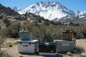 The Hydro Flask Carry Out 20L sits on top of the RTIC Ultralight 52. The Coleman Steel Belted cooler is in the middle, with the RTIC Soft Pack sitting on top of the Coleman 316 Series 70QT to the right.
