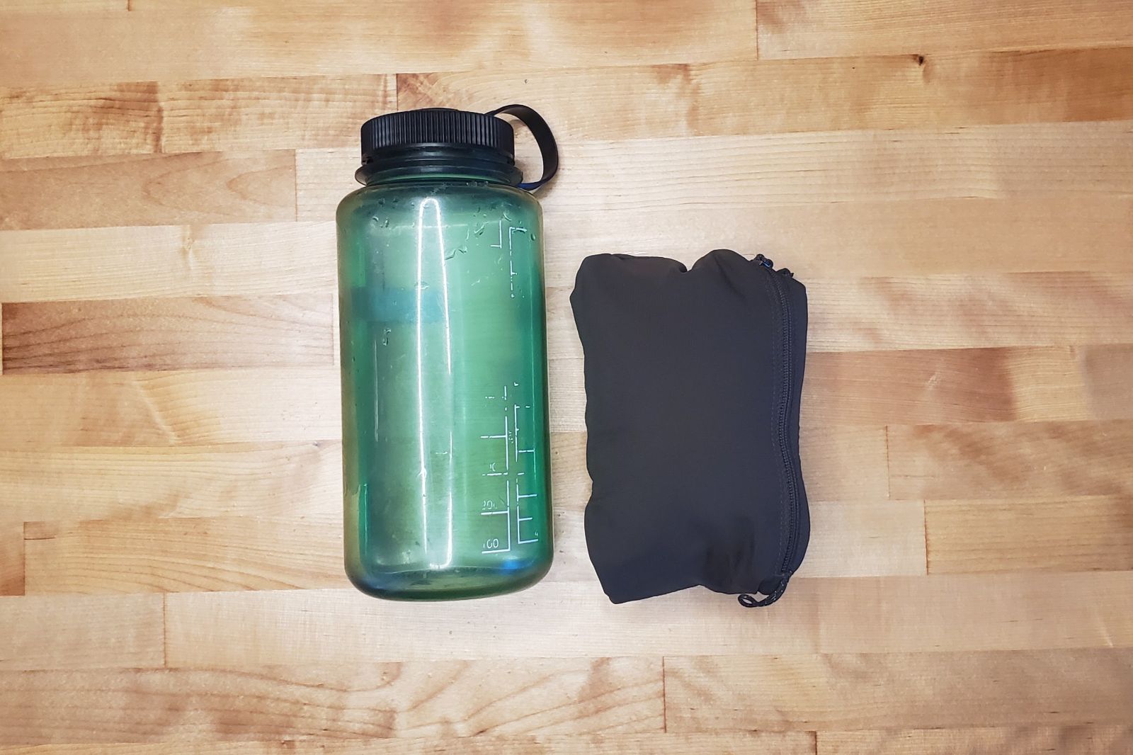 A packed windbreaker compared to a one liter bottle.