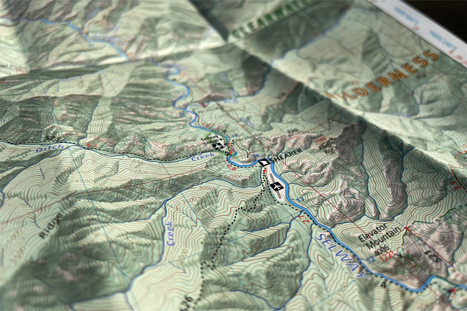 Close up of a map for the Selway Wilderness. The section shows topographic lines, the Selway river, some trail lines, and marks different features.