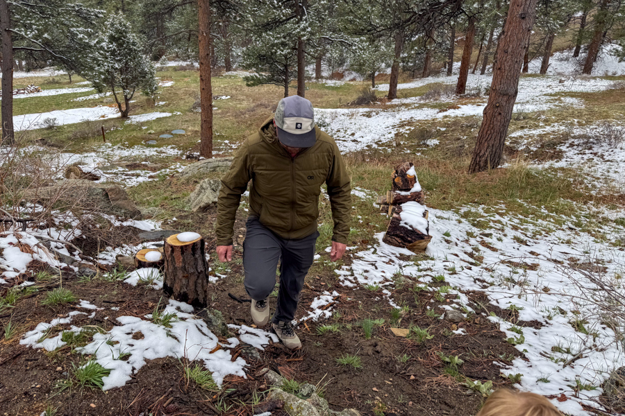 Hiker ascending a lightly snow-covered slope wearing Keen Hightrail Mid boots.