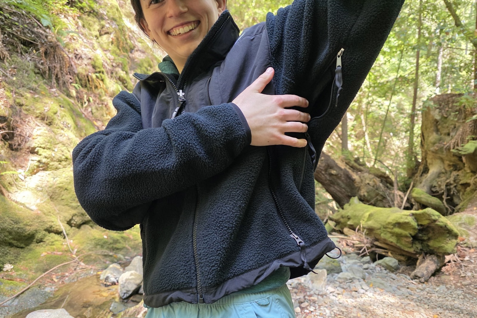 Woman lifting up the arm of her fleece to showcase the large pit zips.