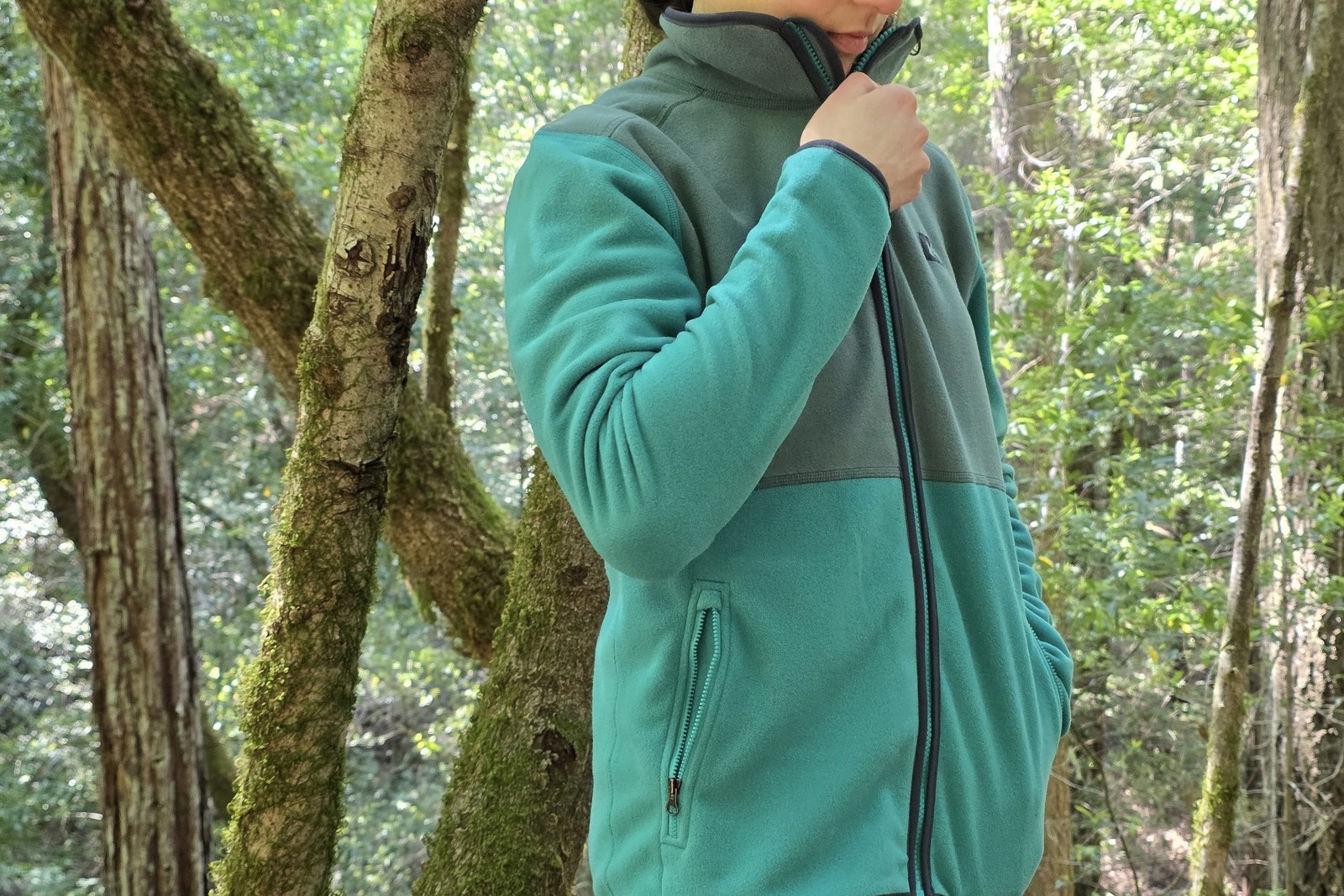Close up of a woman zipping up her fleece jacket.