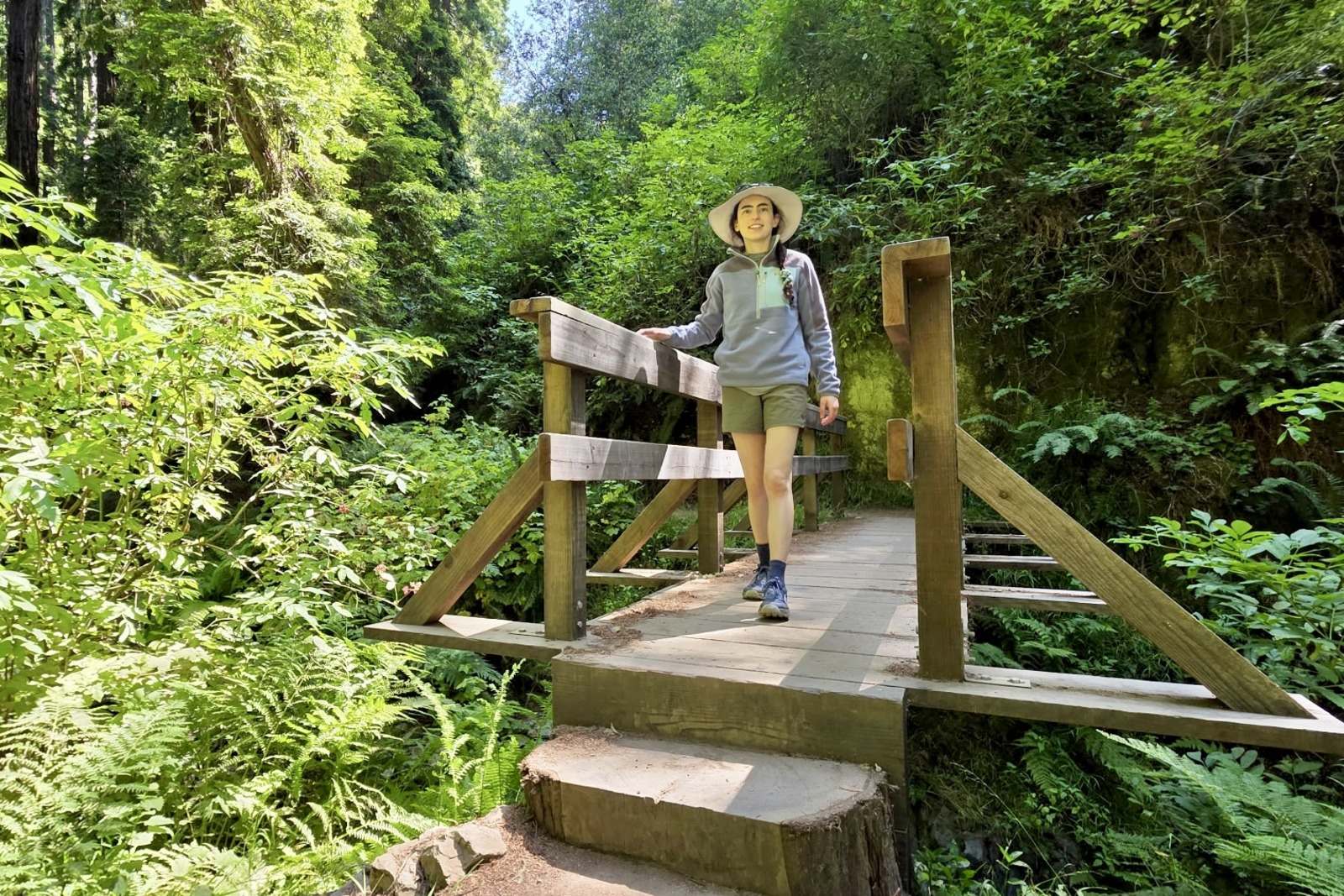 Woman walks along a bridge on her hike.
