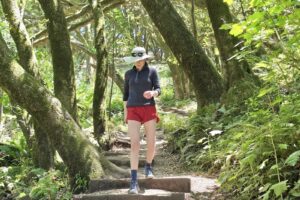A woman hikes down a trail, showcasing her red Rabbit shorts.