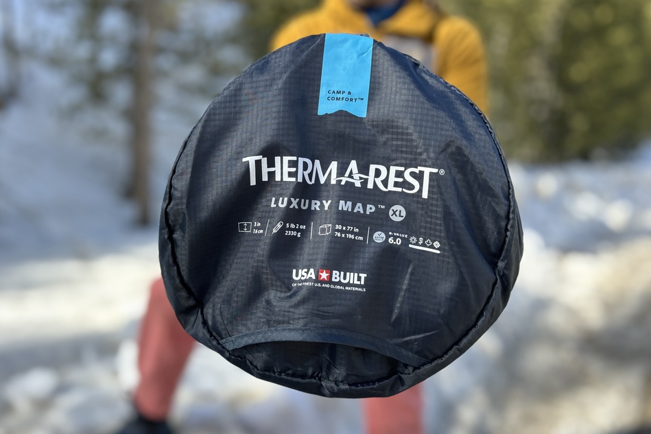 Up-close image of the top of a camping mattress in its stuff sack with logos visible.