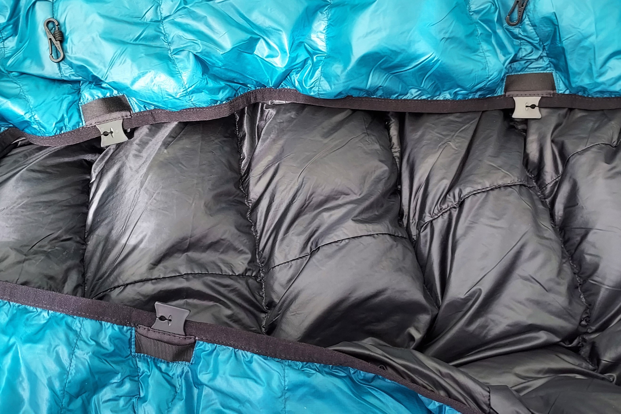 Close up of the Katabatic Flex 22 Quilt pad strap clips