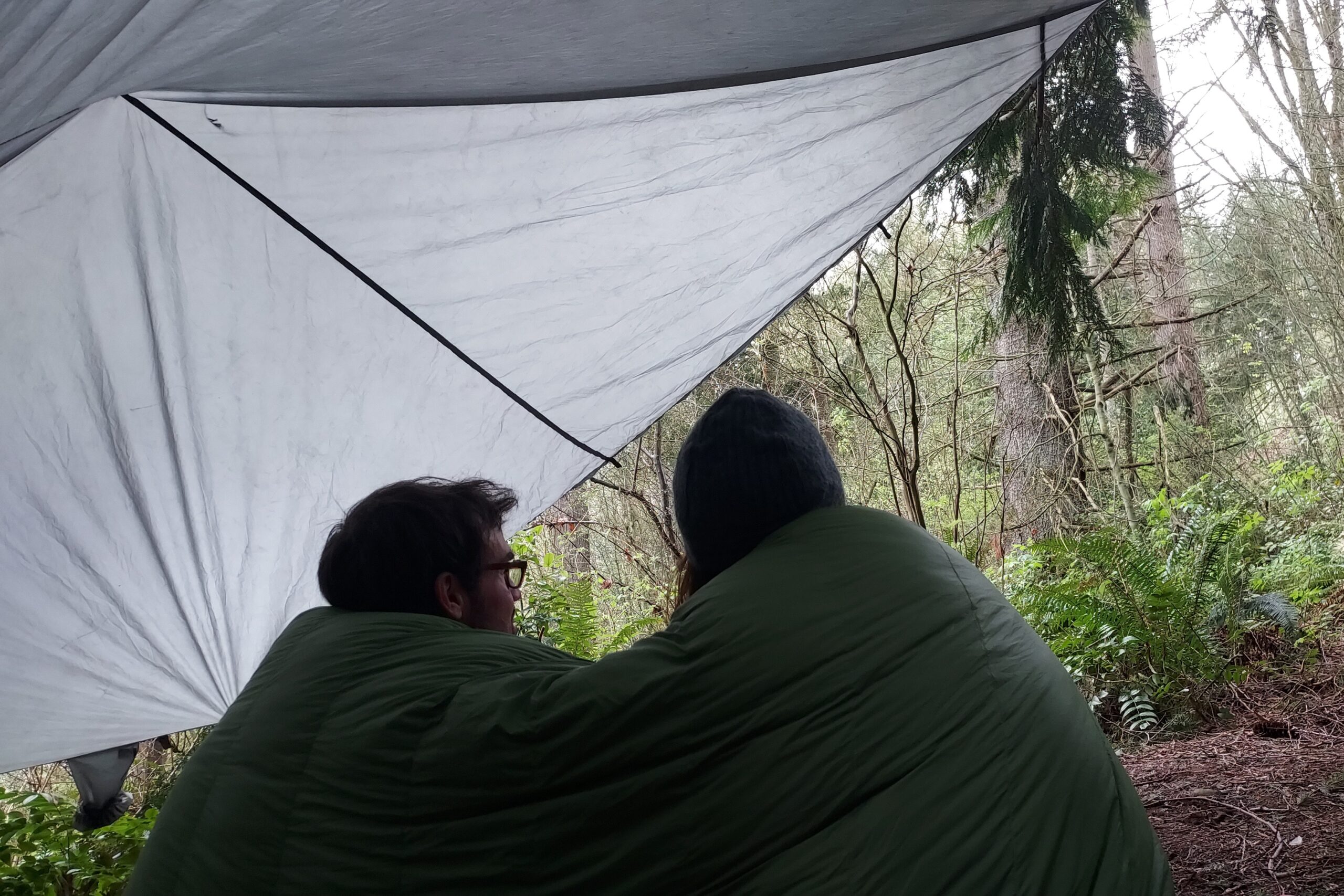 Enlightened Equipment Accomplice Quilt with couple under tarp