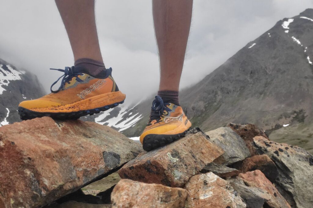 A closeup of shoes standing on rocks.