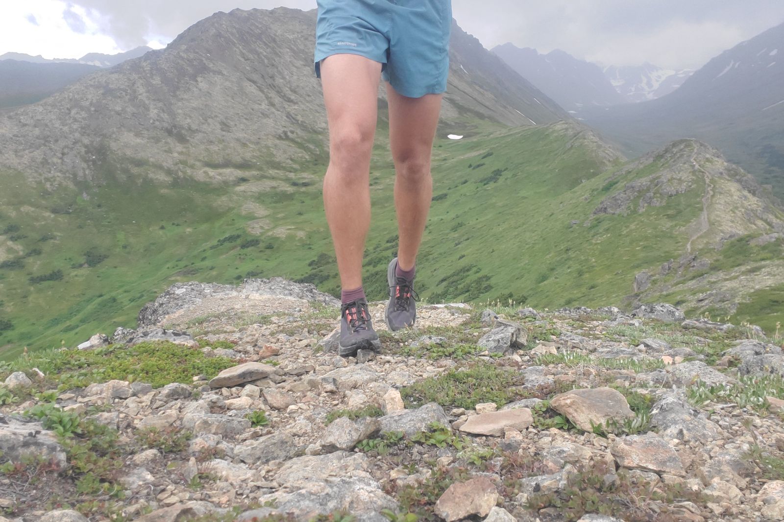 A man hikes along a ridgeline in the alpine.