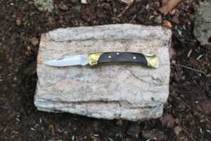 The Buck Knives 055 Pocket Knife open on a rock