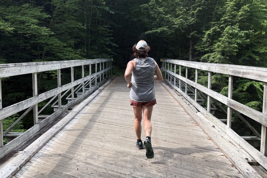 Runner on a bridge wearing the Altra Lone Peak 9+
