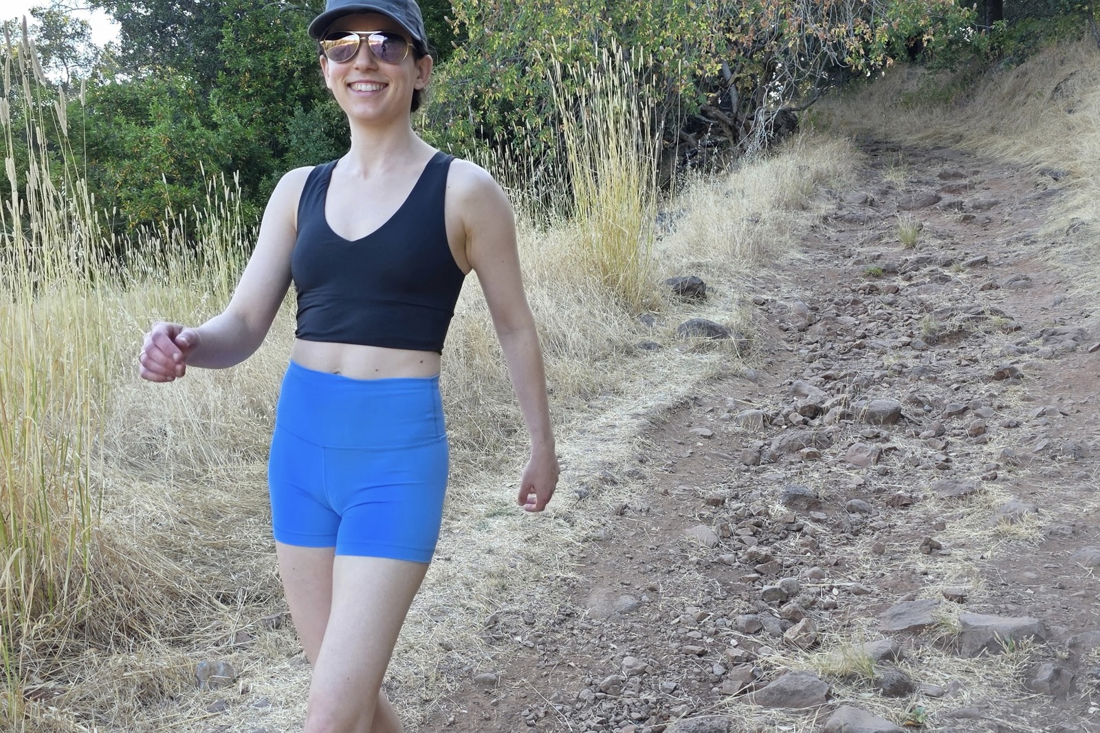 A woman hikes down a trail in her compression shorts.