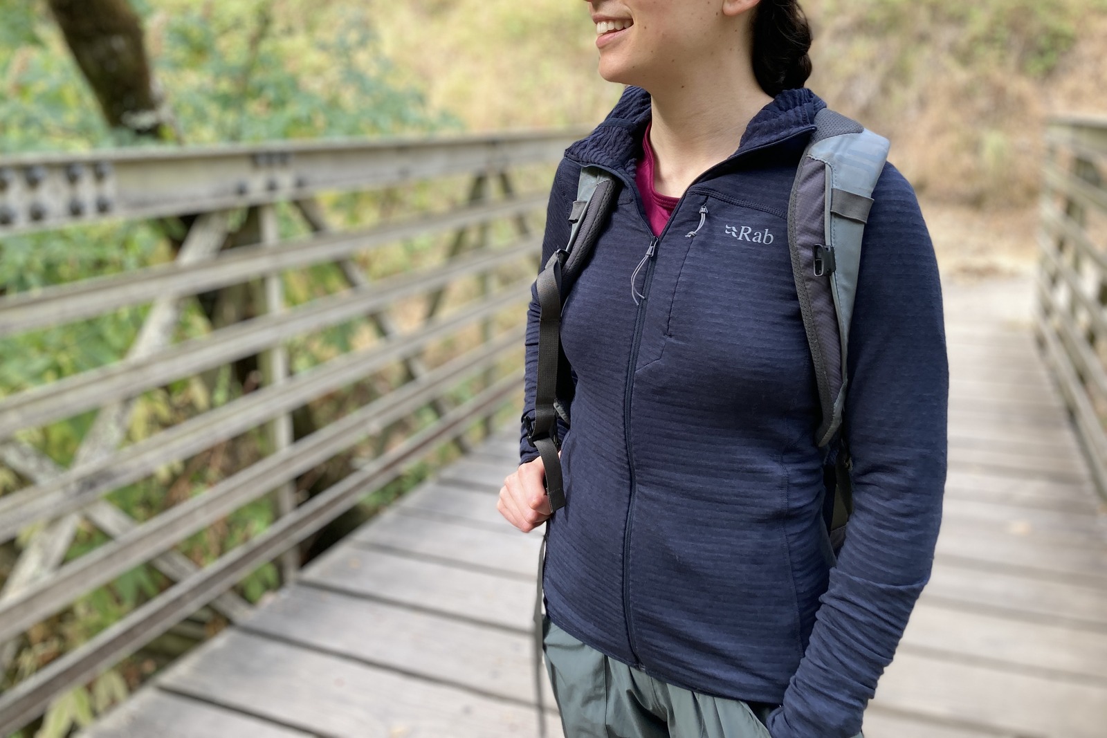 Close up showing a woman wearing a backpack over her fleece jacket.