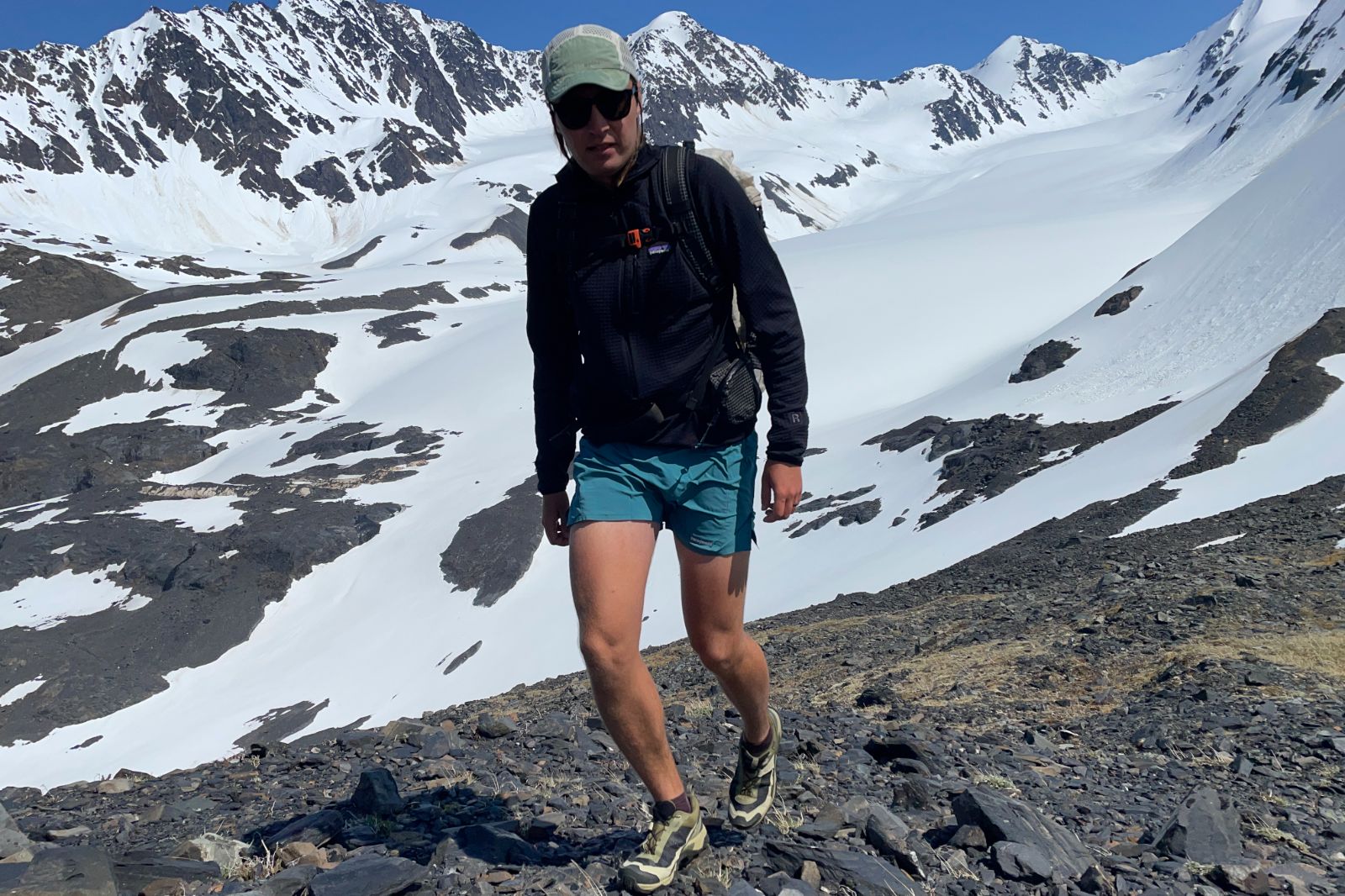 A man hikes in front of a glacier.