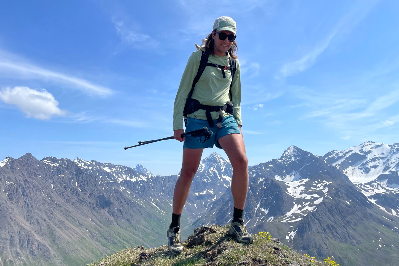 A man hikes along a mountain summit.