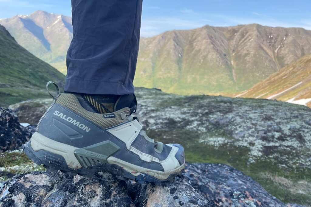 A closeup of hiking shoes at sunset in the mountains.