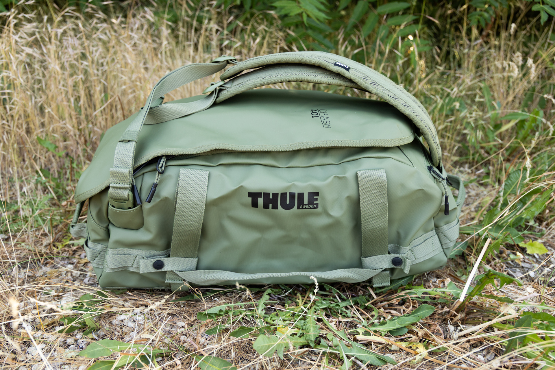 A side view of the Thule Chasm 40L Duffel with shoulder straps attached and duffel handles clipped down to the sides.