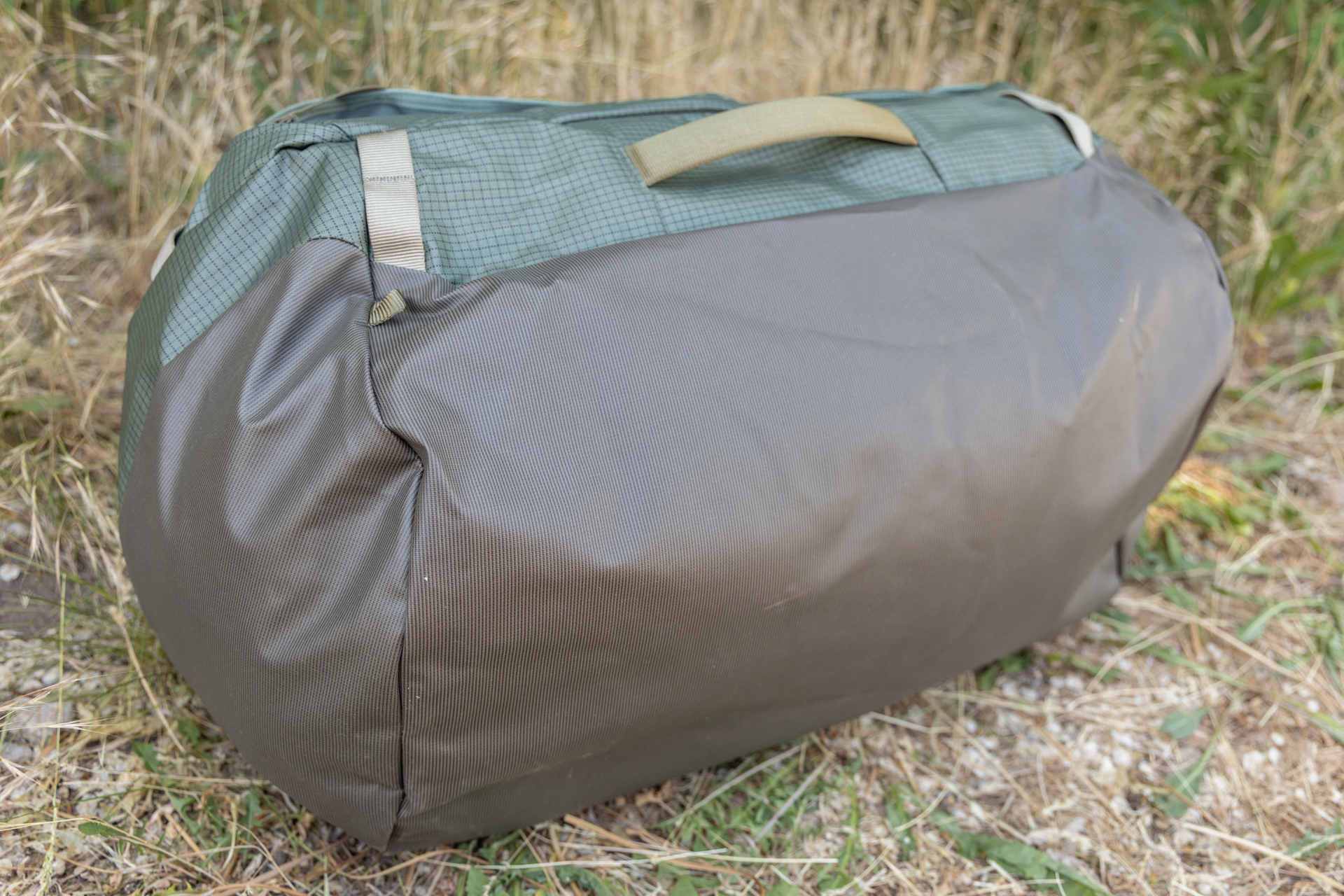 The bottom of the Osprey Transporter duffel is made of a durable, water resistant material that extends part way up the side of the bag.