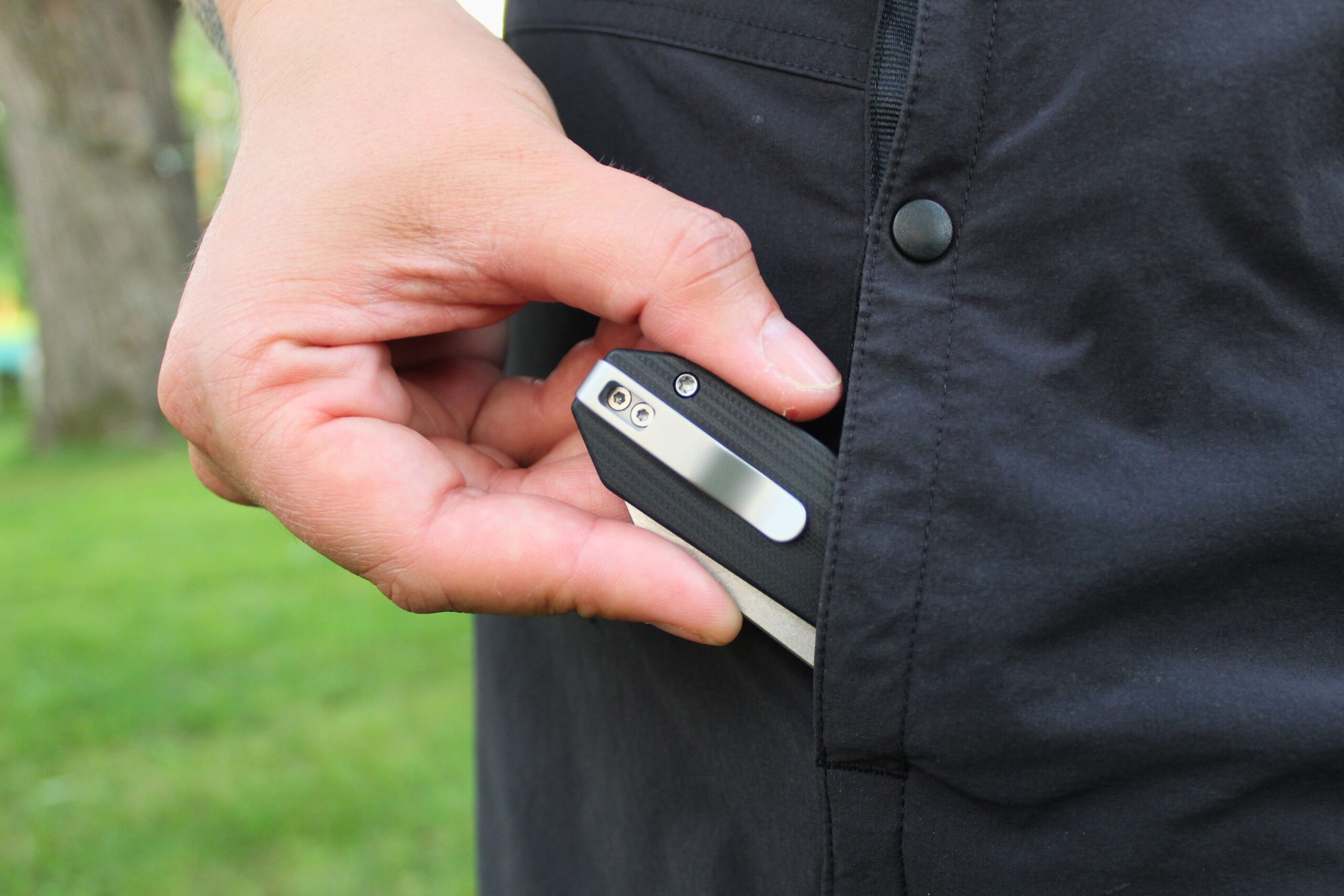 Sliding the Civivi Yonder G10 Pocket Knife into the pocket of hiking shorts