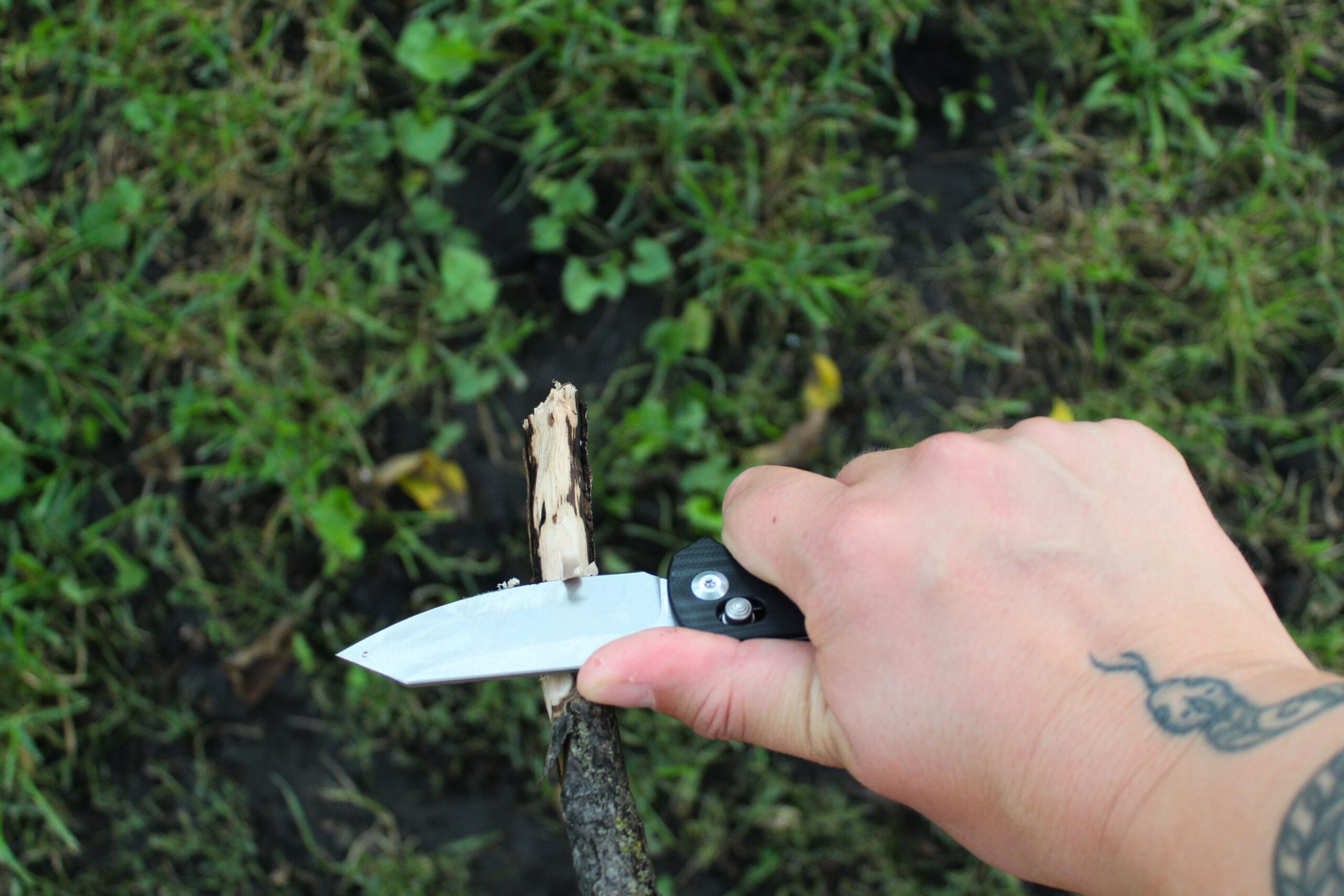 Close up of the Civivi Yonder G10 Pocket Knife sharpening a stick.